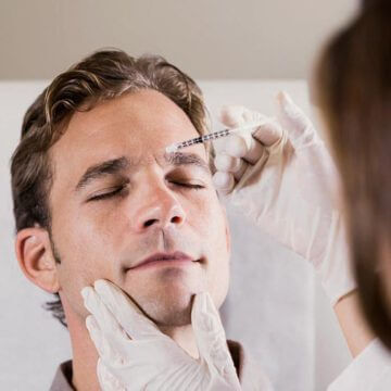 Hombre recibiendo una aplicación de acido hialurónico en su entrecejo.