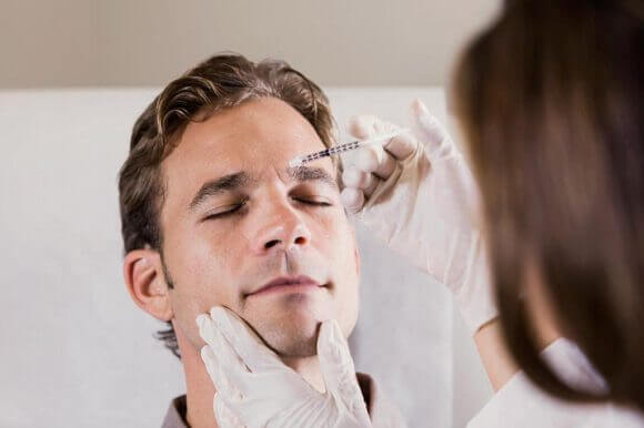 acido-hialuronico-entrecejo Hombre recibiendo una aplicación de acido hialurónico en su entrecejo.